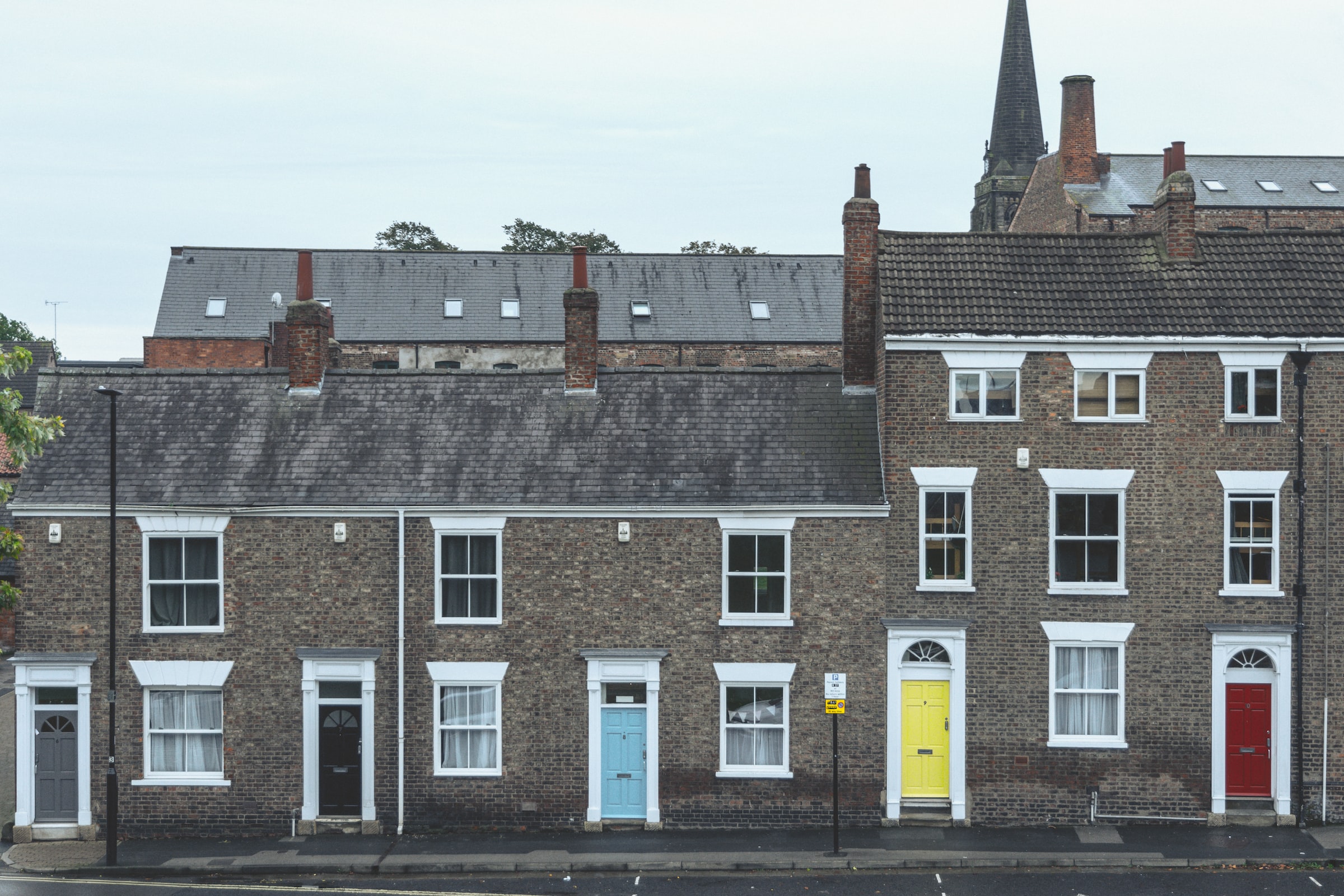 Photo of a row of UK houses with different coloured doors