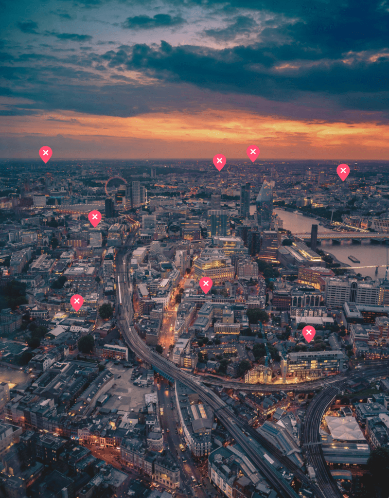 An aerial view of London at dusk with markers over individual properties